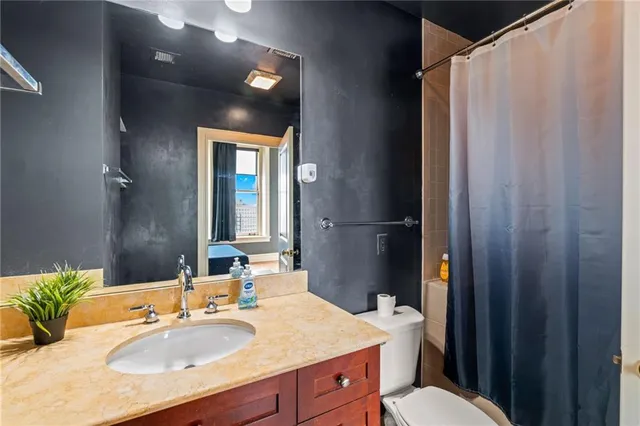 a bathroom with a granite countertop sink toilet and shower