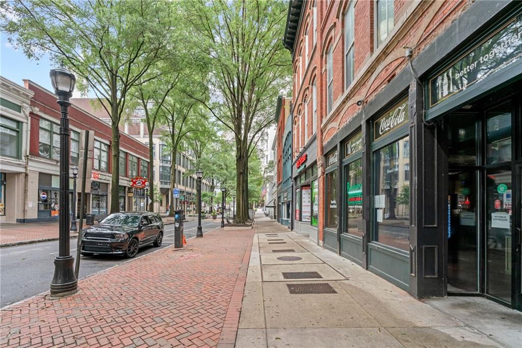 57 Forsyth Street Northwest, Unit 14H Atlanta, GA 30303 - Photo 32 of 42 a street view with tall buildings and cars parked on road