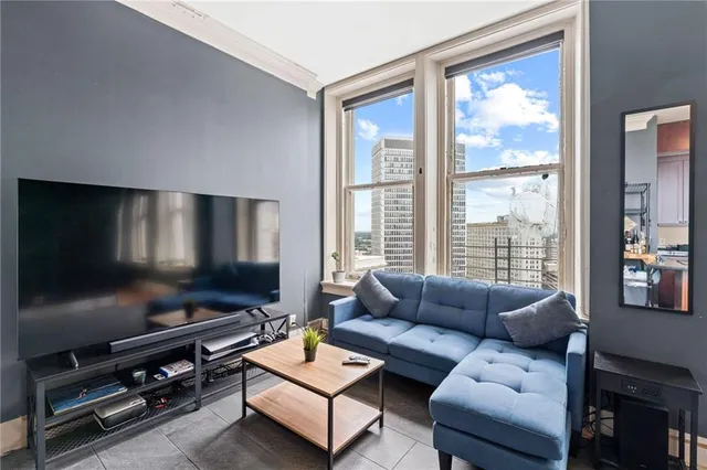 a living room with furniture a flat screen tv and a window
