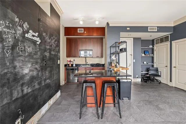 a room with stainless steel appliances kitchen island granite countertop furniture and a living room