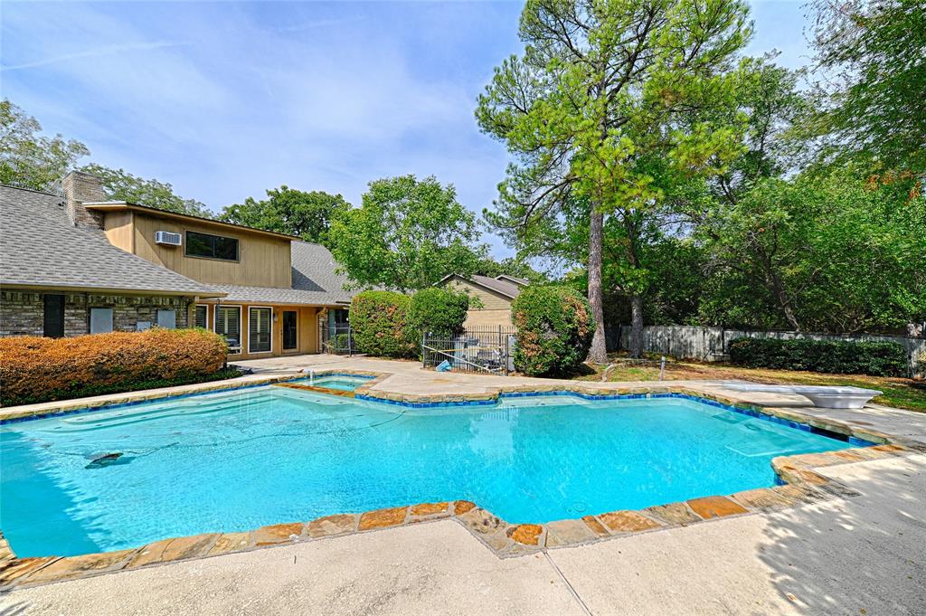 3004 Wingren Road Irving, TX 75062 - Photo 18 of 18 Expansive backyard featuring a custom-shaped swimming pool with stone coping, an integrated spa, and a concrete deck