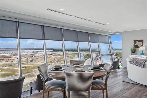 a dining room with furniture water view and a floor to ceiling window