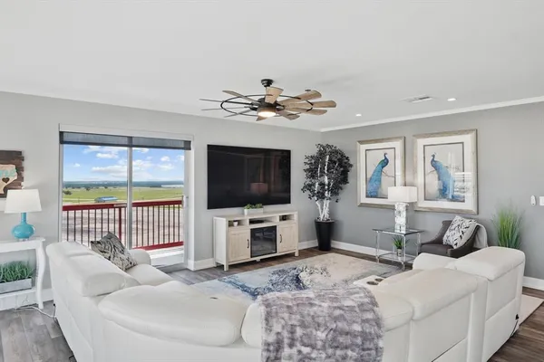 a living room with furniture a flat screen tv and a large window