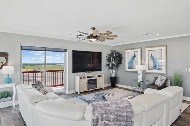 a living room with furniture a flat screen tv and a large window
