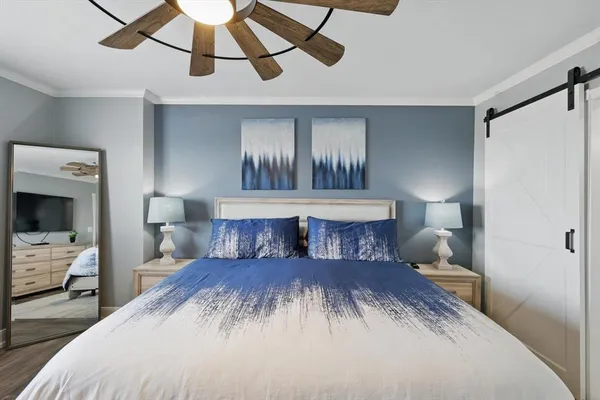 a bedroom with a large bed and a chandelier