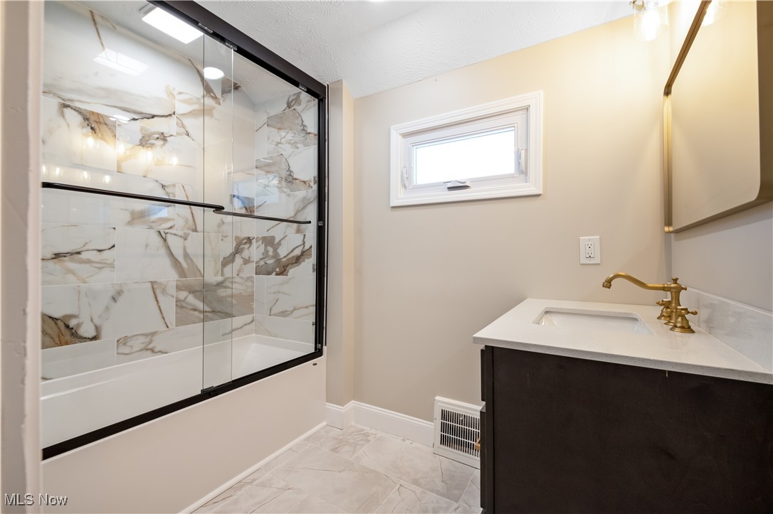 3716 Rolliston Road Cleveland, OH 44120 - Photo 32 of 37 Full bathroom featuring light marble finish floors, bath / shower combo with glass door, and vanity
