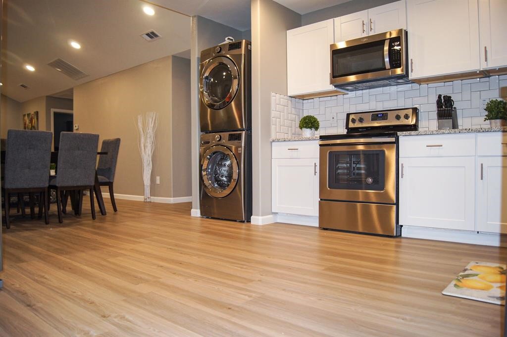 1727 Pueblo Street Dallas, TX 75212 - Photo 9 of 27 a open kitchen with stainless steel appliances granite countertop a refrigerator a stove top oven a dining table and chairs with wooden floor