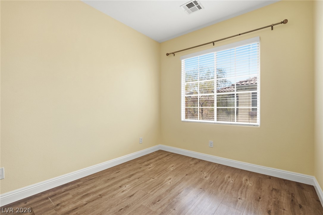 8932 Caledon Ridge Court Las Vegas, NV 89149 - Photo 30 of 39 Gleaming wood-look floors complement a large window equipped with blinds.