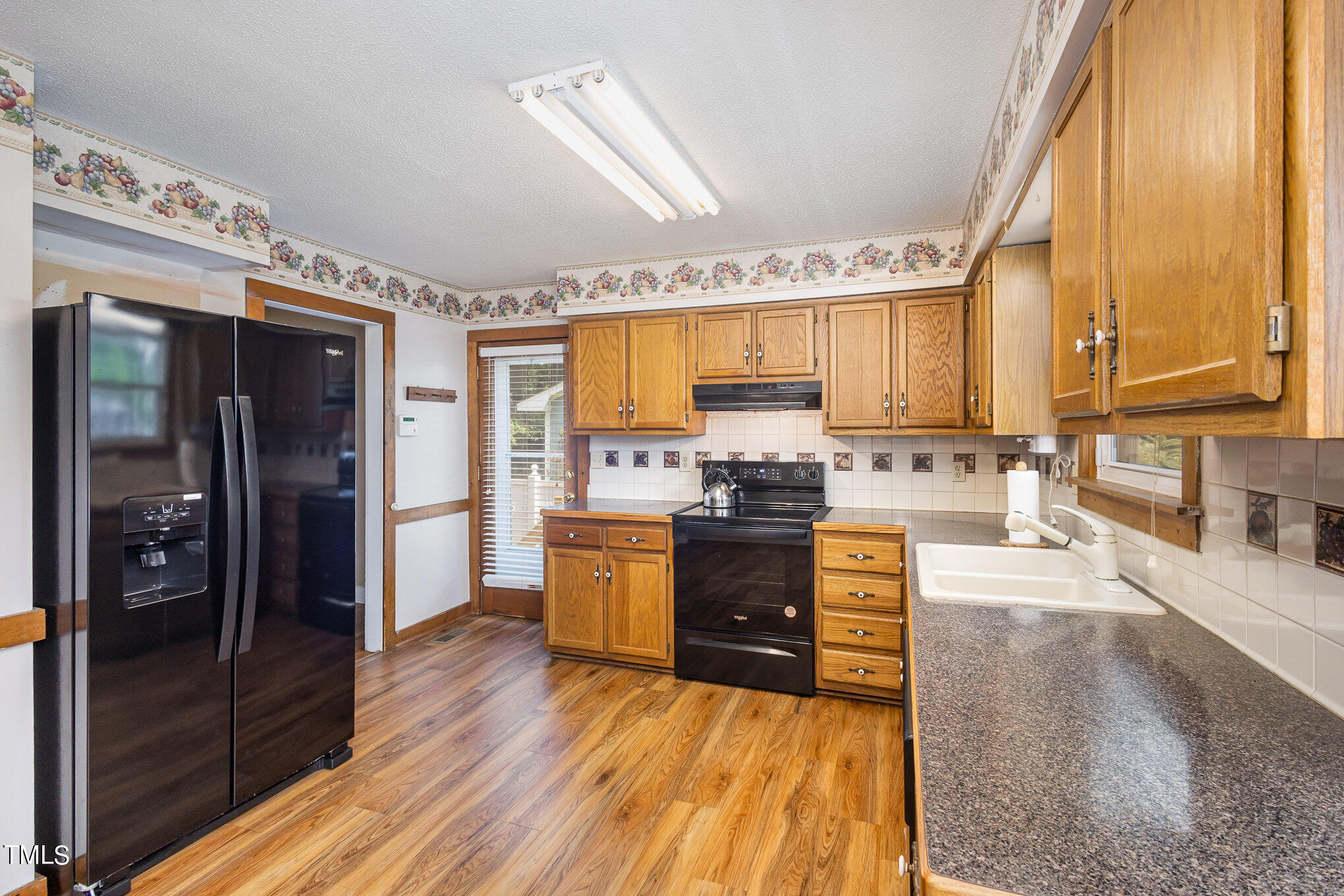 814 Wyldewood Road Durham, NC 27704 - Photo 9 of 26 a kitchen with stainless steel appliances a refrigerator sink and cabinets