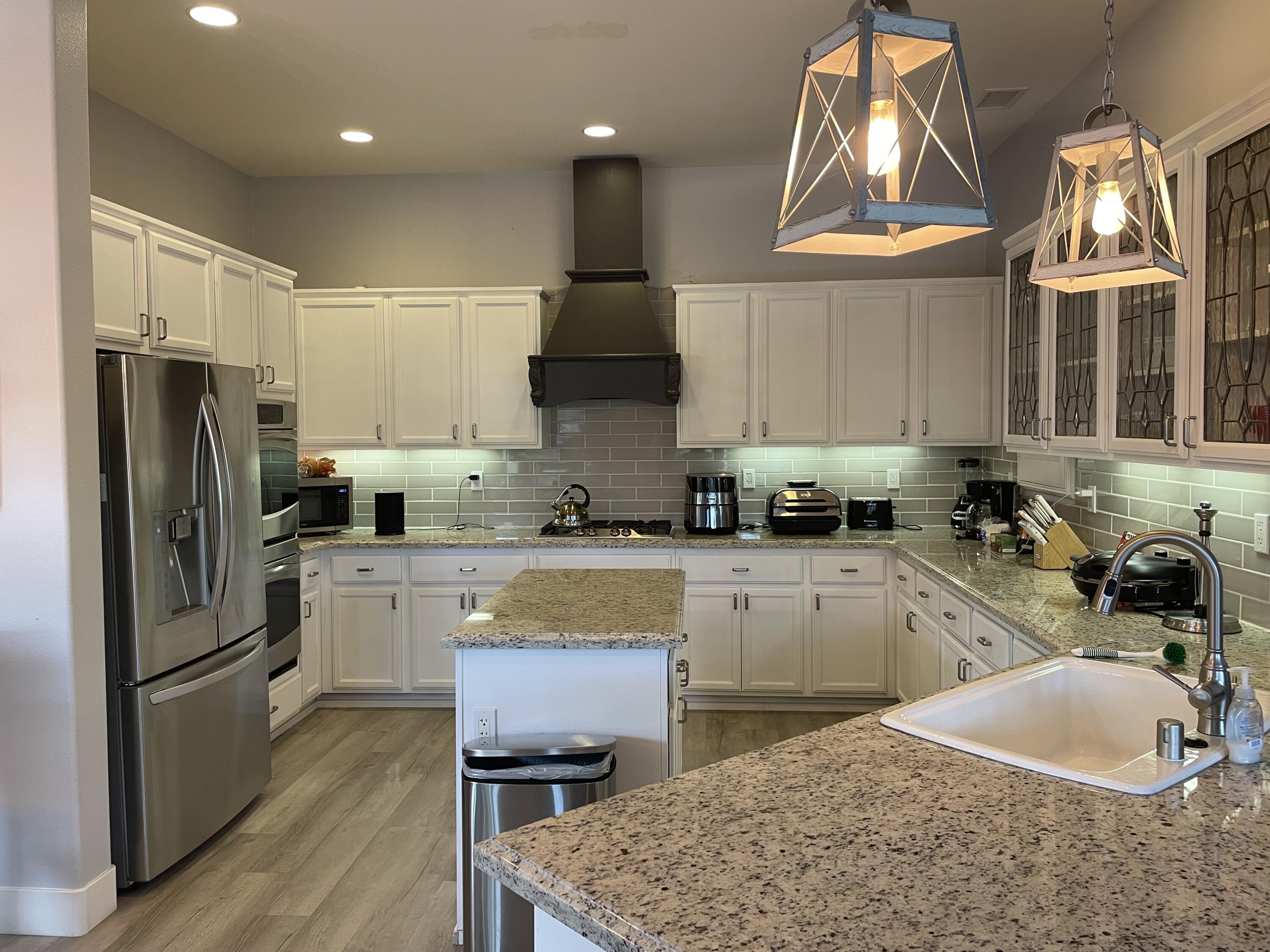 61232 Cactus Spring Drive La Quinta, CA 92253 - Photo 2 of 30 a kitchen with stainless steel appliances granite countertop a sink a stove a refrigerator and cabinets