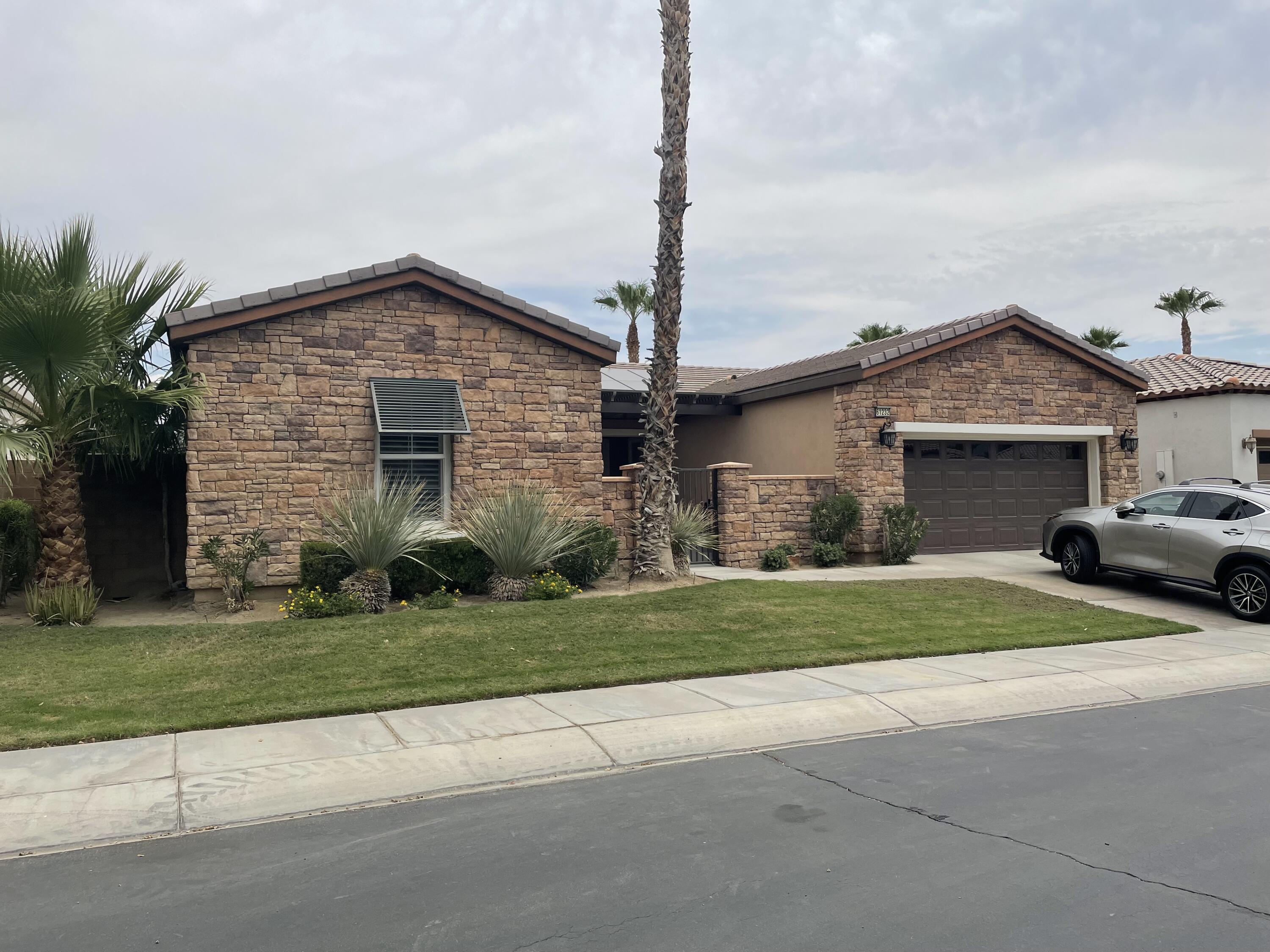 61232 Cactus Spring Drive La Quinta, CA 92253 - Photo 29 of 30 a front view of a house with a yard and garage