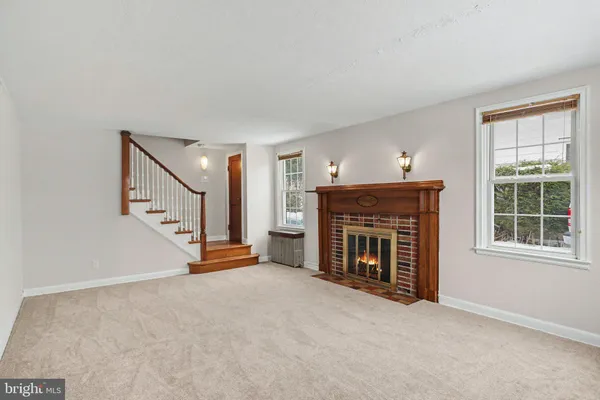 a view of an empty room with fireplace and a window