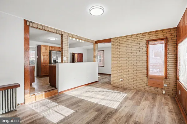 a view of a hallway with wooden floor and a living room