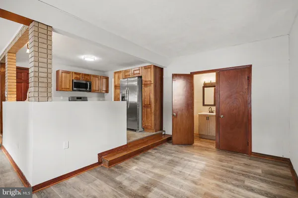 a view of a kitchen with a refrigerator a microwave and a sink