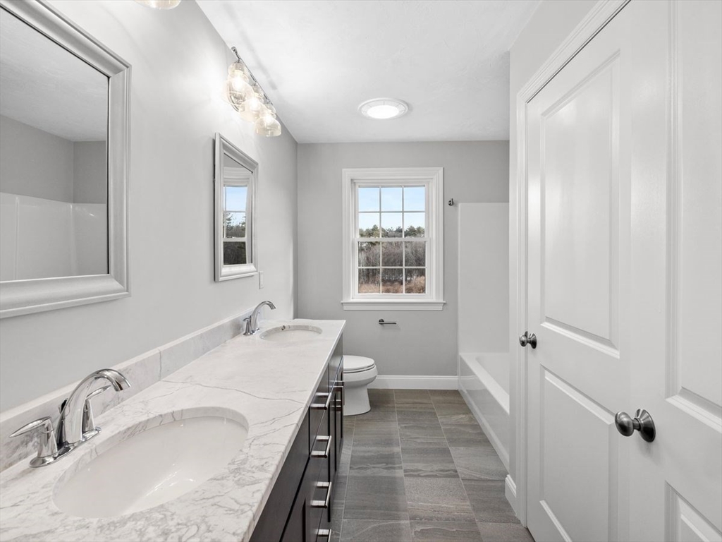 46 Lackey Street Westborough, MA 01581 - Photo 35 of 42 a spacious bathroom with a granite countertop sink a mirror and a bathtub