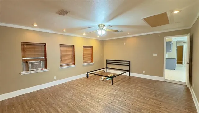 a view of a room with wooden floor and a ceiling fan
