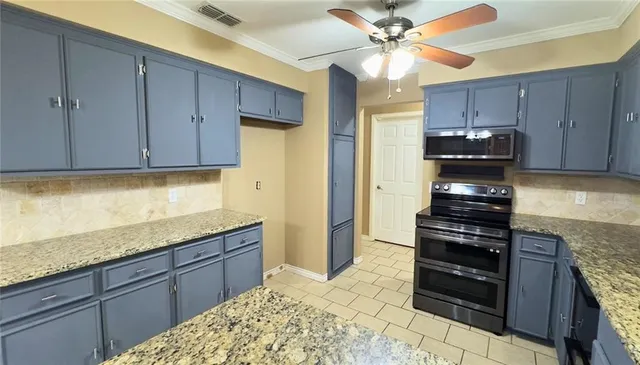 a kitchen with granite countertop wooden cabinets and black appliances