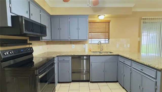 a kitchen with stainless steel appliances granite countertop a sink a stove a microwave and cabinets