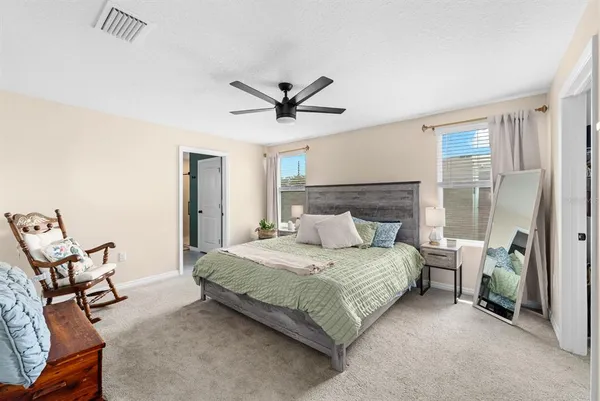a bedroom with a bed a chair and a chandelier