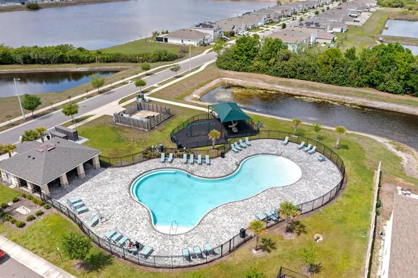 an aerial view of a house with swimming pool and outdoor seating