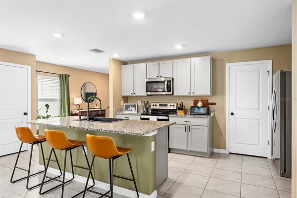 a kitchen with stainless steel appliances granite countertop a refrigerator and a stove top oven