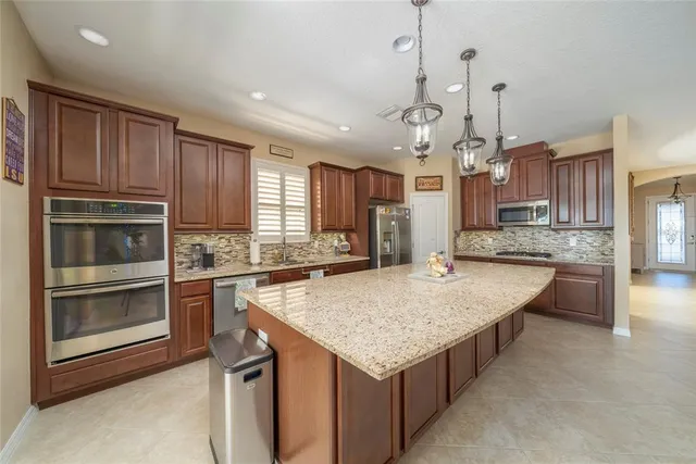 a kitchen with kitchen island granite countertop wooden cabinets a stove and center island