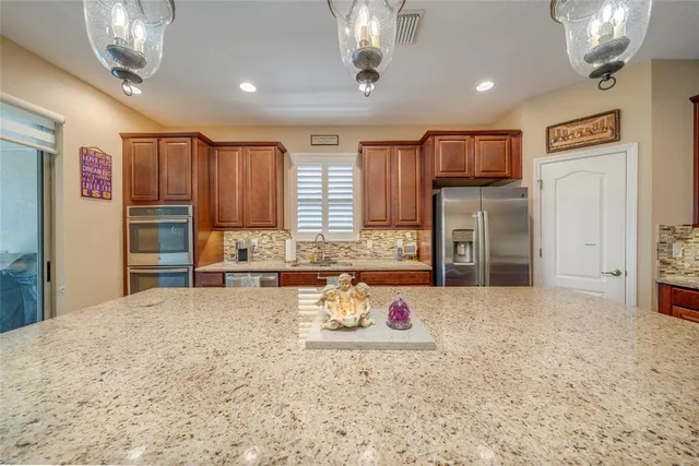 a kitchen with stainless steel appliances granite countertop a stove refrigerator and cabinets