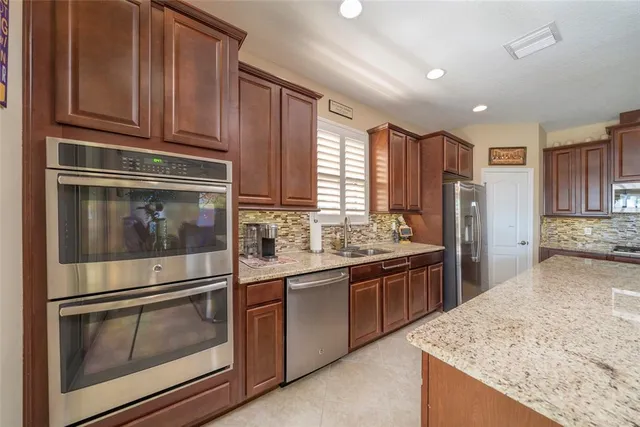 a kitchen with granite countertop a refrigerator and stove