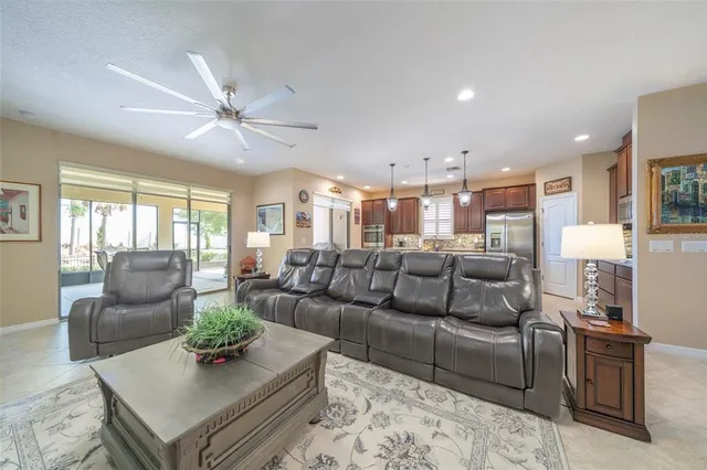 a living room with furniture kitchen view and a chandelier