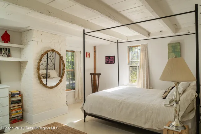 a bedroom with a bed a mirror and a window