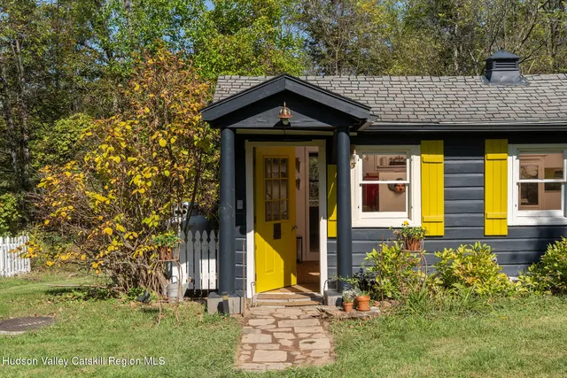 a view of a house with potted plants and a yard