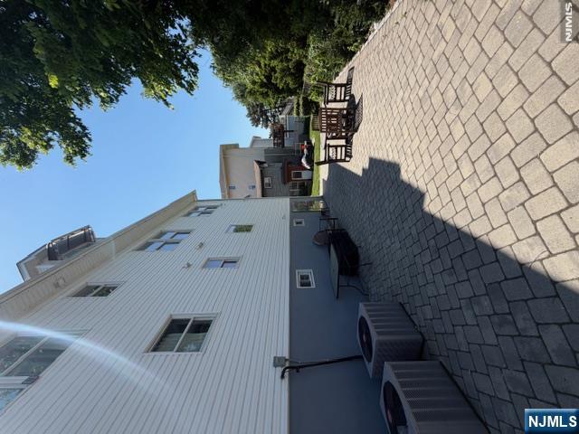 177 Maple Street Fairview, NJ 07022 - Photo 23 of 24 a view of a patio with table and chairs couches under an umbrella with a fire pit