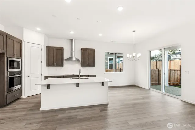 a large kitchen with stainless steel appliances a sink dishwasher stove refrigerator and microwave