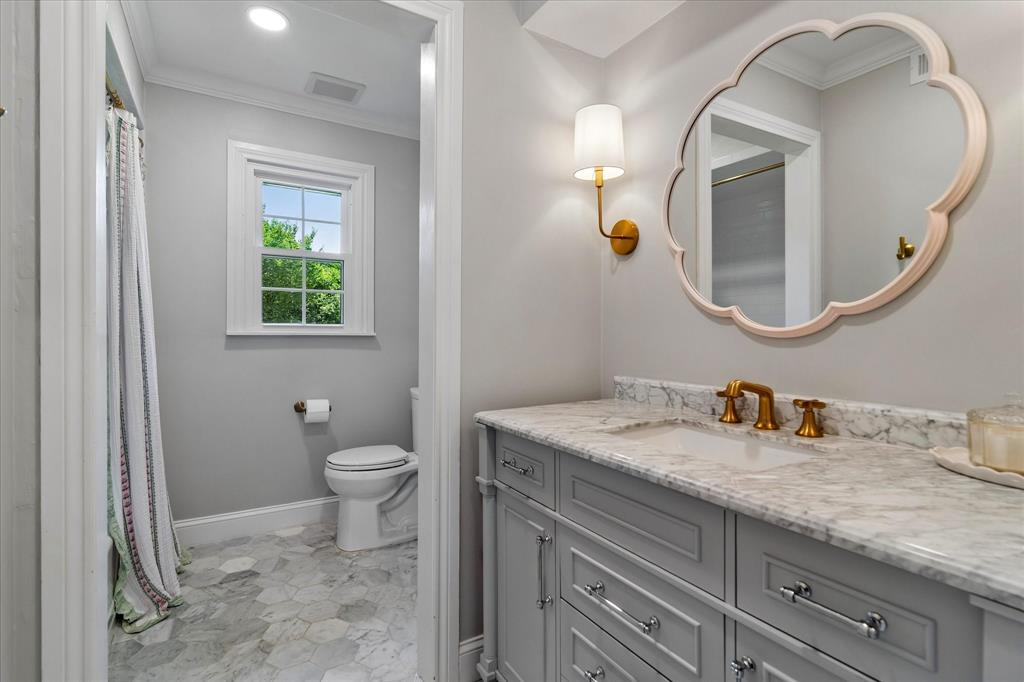 11439 Rosser Road Dallas, TX 75229 - Photo 27 of 35 a bathroom with a granite countertop toilet a sink and a mirror