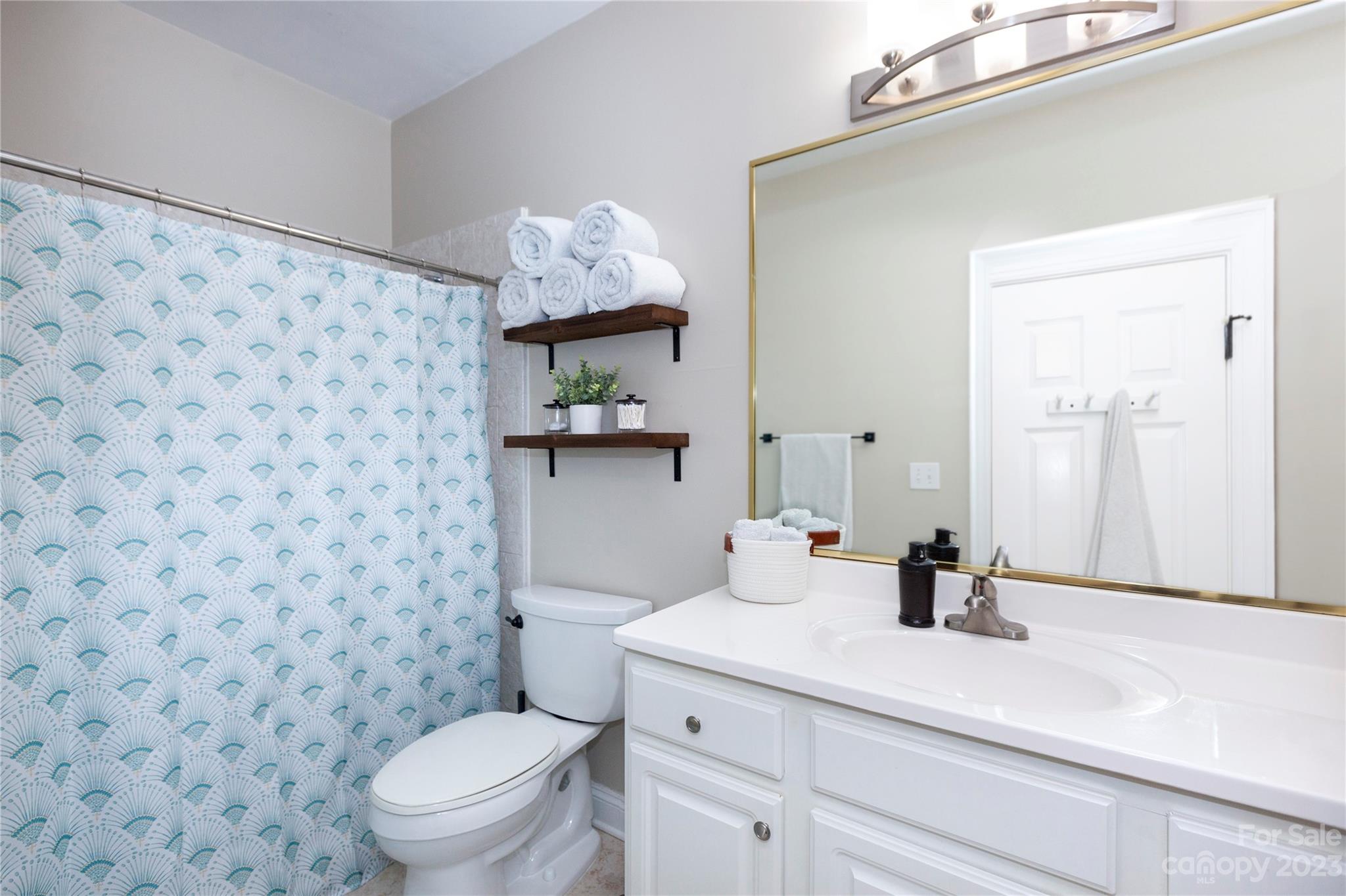 5601 Fairview Road, Unit 19 Charlotte, NC 28209 - Photo 24 of 30 a bathroom with a granite countertop sink a toilet and shower curtain