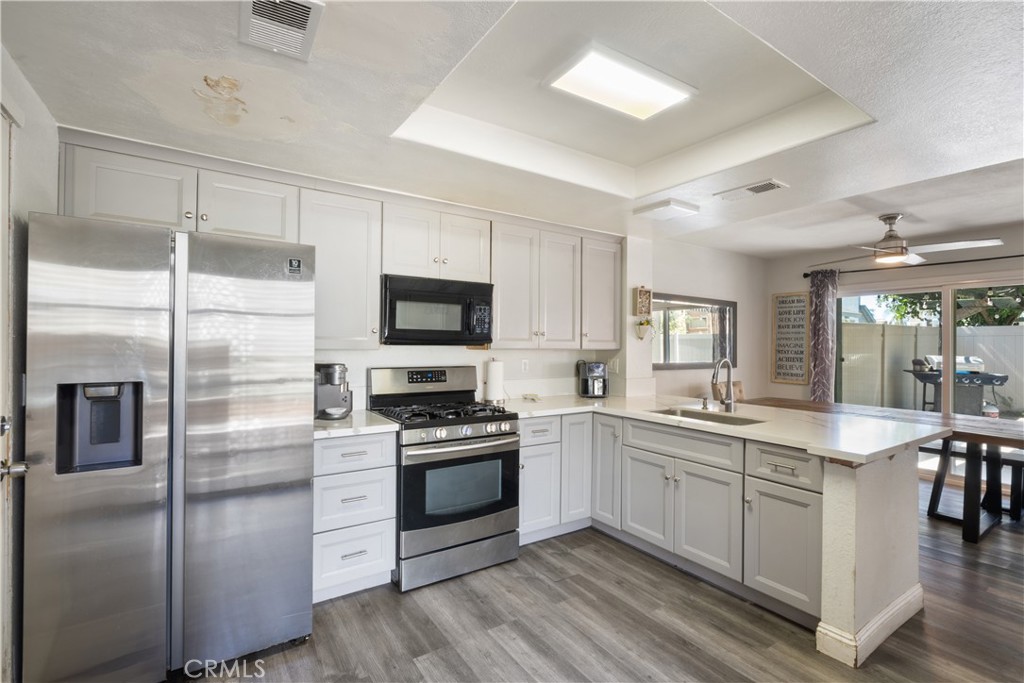 11840 Rustic Place Fontana, CA 92337 - Photo 6 of 20 a kitchen with a sink stainless steel appliances and white cabinets