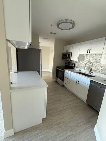 a kitchen with stainless steel appliances a sink a stove and a refrigerator