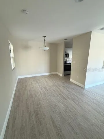 a view of empty room with wooden floor
