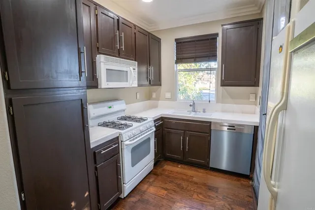 a kitchen with stainless steel appliances granite countertop a refrigerator a sink and a stove