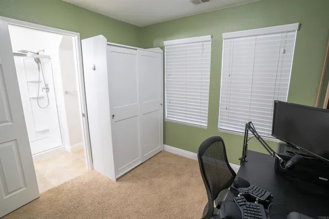 a view of a workspace with furniture and a window