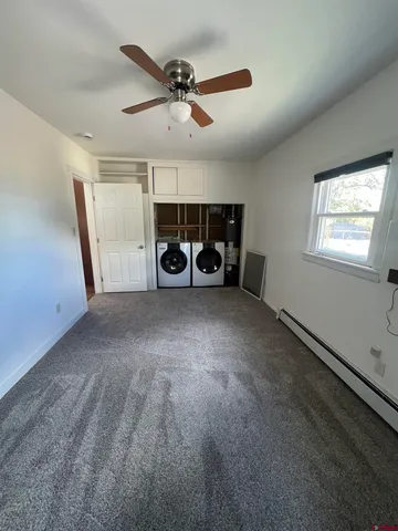 a view of a livingroom with a ceiling fan and window