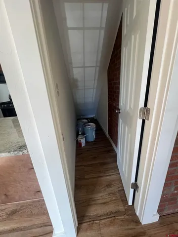 a view of a hallway with wooden floor and staircase