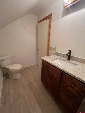 a bathroom with a granite countertop sink a toilet and a mirror