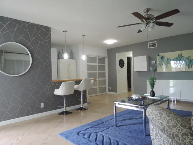 a living room with furniture a table and wooden floor