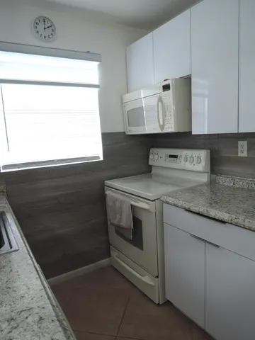 a stove top oven sitting inside of a kitchen