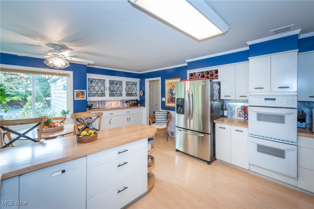 911 Merriman Road Akron, OH 44303 - Photo 10 of 48 Kitchen with white cabinets, wooden counters, stainless steel refrigerator with ice dispenser, white double oven, and light wood-type flooring