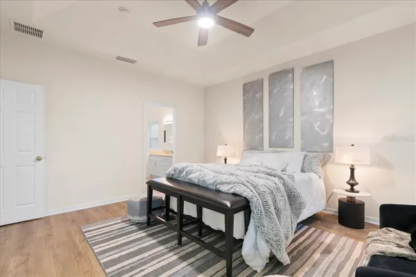 a bedroom with a bed and wooden floor