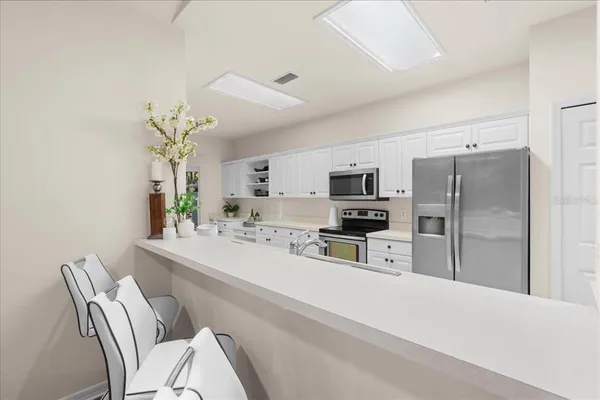 a kitchen with stainless steel appliances a refrigerator sink and microwave