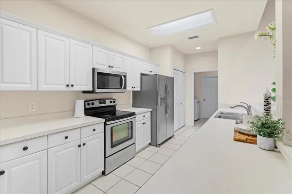 a kitchen with stainless steel appliances a stove a sink a refrigerator a stove a microwave and cabinets