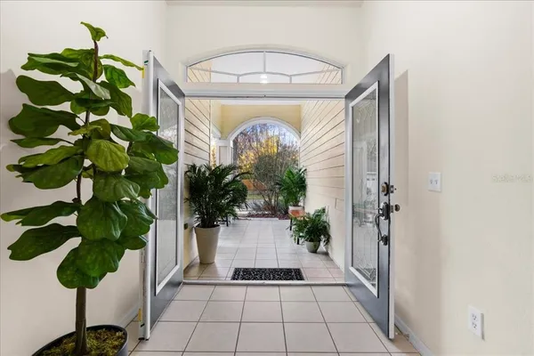 a vase of flowers sitting on a floor in front of a door